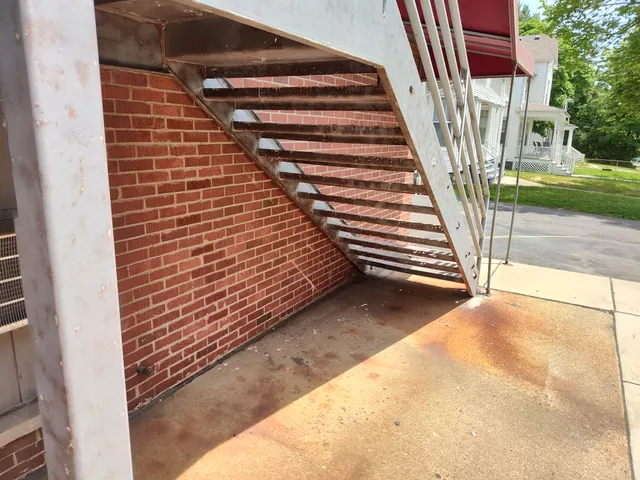 Under-stair structural metalwork and rust staining