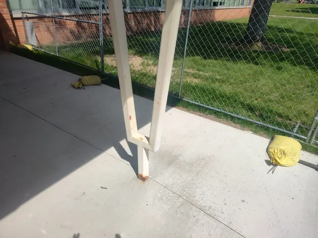 Awning post base — rust bleeding through paint at base plate