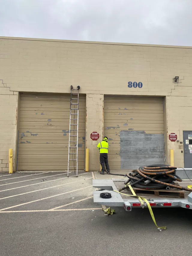 Crew blasting and prepping bay doors on-site