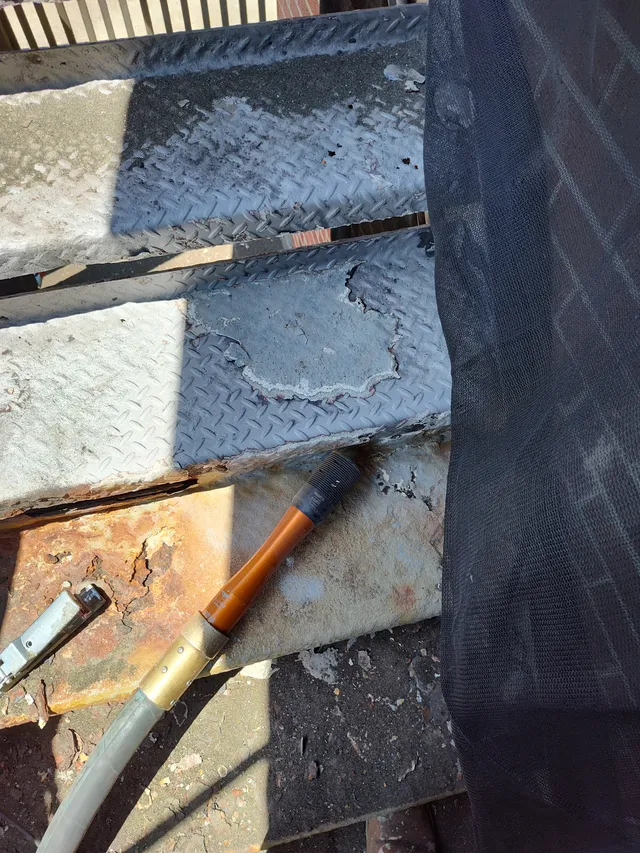 Overhead view of peeling coating and blasting hose