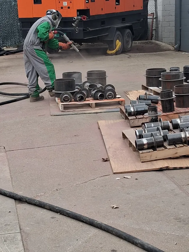 Mobile blasting setup — pipe fittings staged on pallets