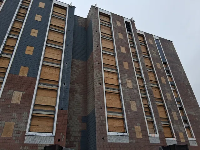 Concord Tower Apartments — upward view of high-rise facade during blast prep